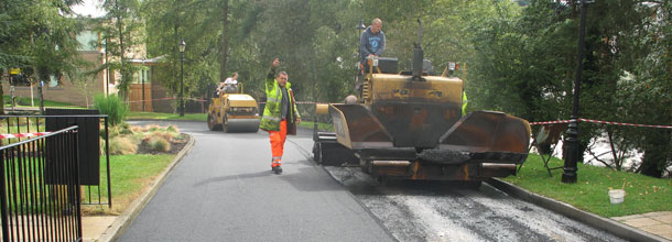 Road being tarmacked with man waving 